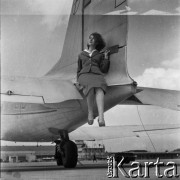 Lata 50., Warszawa, Polska.
Lotnisko Okęcie, n/z stewardessa Polskich Linii Lotniczych LOT pozuje przy samolocie.
Fot. Irena Jarosińska, zbiory Ośrodka KARTA