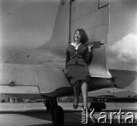 Lata 50., Warszawa, Polska.
Lotnisko Okęcie, n/z stewardessa Polskich Linii Lotniczych LOT pozuje przy samolocie.
Fot. Irena Jarosińska, zbiory Ośrodka KARTA
