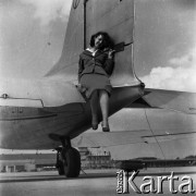 Lata 50., Warszawa, Polska.
Lotnisko Okęcie, n/z stewardessa Polskich Linii Lotniczych LOT pozuje przy samolocie.
Fot. Irena Jarosińska, zbiory Ośrodka KARTA