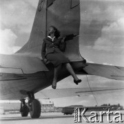 Lata 50., Warszawa, Polska.
Lotnisko Okęcie, n/z stewardessa Polskich Linii Lotniczych LOT pozuje przy samolocie.
Fot. Irena Jarosińska, zbiory Ośrodka KARTA