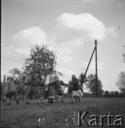1961, Kadzidło, Polska.
Dzieci tańczące wokół kobiety w stroju ludowym.
Fot. Irena Jarosińska, zbiory Ośrodka KARTA
