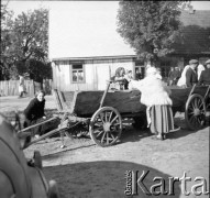 1961, Kadzidło, Polska.
Plac przed kościołem pw. Świętego Ducha. Kobiety i mężczyźni przy furmance. 
Fot. Irena Jarosińska, zbiory Ośrodka KARTA
