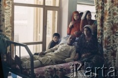 1992, Kabul, prowincja Kabul, Afganistan.
Afgańska rodzina. Kobiety czuwają w szpitalu przy łóżku chorego. Mężczyzna ma na sobie tradycyjny strój - tunikę do kolan (kamiz) oraz zwężane dołem luźne spodnie (salwar).
Fot. Irena Jarosińska, zbiory Ośrodka KARTA