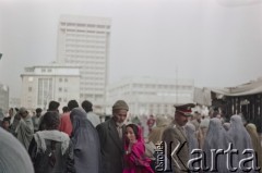 1992, Kabul, prowincja Kabul, Afganistan.
Przechodnie na kabulskiej ulicy. Na dalszym planie widoczny najwyższy budynek w mieście: wzniesiony w czasach sowieckich 18-piętrowy gmach będący siedzibą Ministerstwa Komunikacji i Technologii Informacyjnej.
Fot. Irena Jarosińska, zbiory Ośrodka KARTA