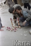 1992, Kabul, prowincja Kabul, Afganistan.
Dwaj chłopcy bawią się na ulicy zabawkowym drewnianym czołgiem i działkiem.
Fot. Irena Jarosińska, zbiory Ośrodka KARTA