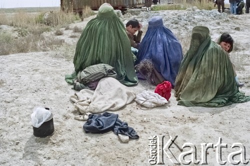 1992, Kabul, prowincja Kabul, Afganistan.
Afgańska rodzina w obozowisku. Kobiety maja na sobie tradycyjny strój zakrywający całe ciało - pełną burkę, zwaną tez burką afgańską.
Fot. Irena Jarosińska, zbiory Ośrodka KARTA