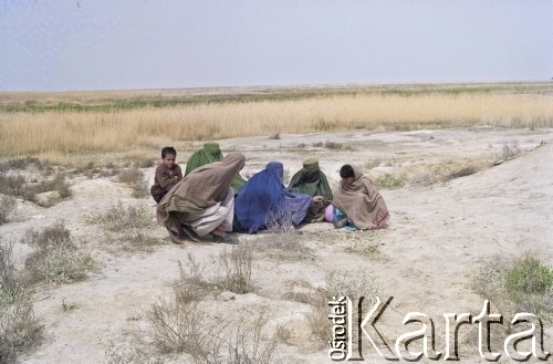 1992, Kabul, prowincja Kabul, Afganistan.
Afgańska rodzina w obozowisku. Kobiety maja na sobie tradycyjny strój zakrywający całe ciało, tak zwaną pełną burkę (burkę afgańską).
Fot. Irena Jarosińska, zbiory Ośrodka KARTA