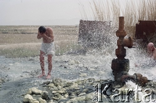 1992, Kabul, prowincja Kabul, Afganistan.
Konwój podczas postoju w obozowisku. Na zdjęciu mężczyzna bierze kąpiel korzystając z zaimprowizowanego natrysku przy hydrancie. 
Fot. Irena Jarosińska, zbiory Ośrodka KARTA