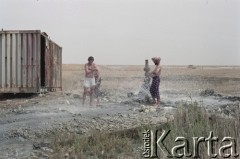 1992, Kabul, prowincja Kabul, Afganistan.
Konwój podczas postoju w obozowisku. Na zdjęciu mężczyźni biorą kąpiel korzystając z zaimprowizowanego natrysku przy hydrancie. 
Fot. Irena Jarosińska, zbiory Ośrodka KARTA