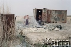 1992, Kabul, prowincja Kabul, Afganistan.
Konwój podczas postoju w obozowisku. Na zdjęciu mężczyźni biorą kąpiel korzystając z zaimprowizowanego natrysku przy hydrancie. 
Fot. Irena Jarosińska, zbiory Ośrodka KARTA