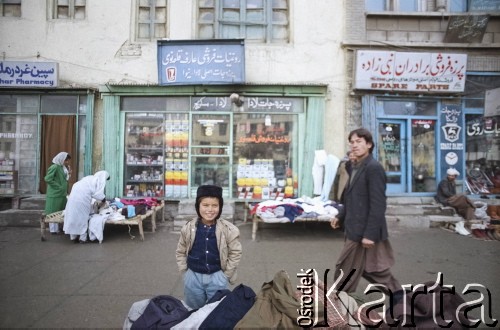 1992, Kabul, prowincja Kabul, Afganistan.
Stragany i sklepy przy kabulskiej ulicy. Na budynkach widoczne szyldy zakładów usługowych.
Fot. Irena Jarosińska, zbiory Ośrodka KARTA