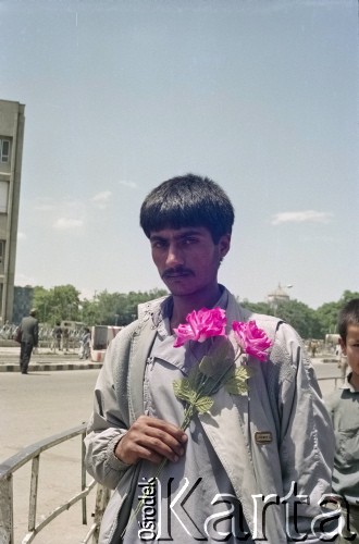 1992, Kabul, prowincja Kabul, Afganistan.
Młody mężczyzna z bukietem sztucznych kwiatów.
Fot. Irena Jarosińska, zbiory Ośrodka KARTA