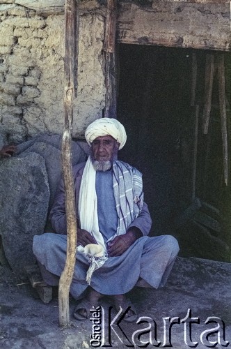 1992, Kabul, prowincja Kabul, Afganistan.
Portret mężczyzny siedzącego przed wejściem do domu. Mężczyzna ma na sobie tradycyjny strój- tunikę (kamiz), szerokie spodnie (salwar) oraz turban (longi).
Fot. Irena Jarosińska, zbiory Ośrodka KARTA