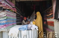 1992, Kabul, prowincja Kabul, Afganistan.
Na targu. Kobieta w burce wybiera tkaniny w sklepie.
Fot. Irena Jarosińska, zbiory Ośrodka KARTA