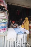 1992, Kabul, prowincja Kabul, Afganistan.
Na targu - kobieta robi zakupy przy stoisku z tkaninami.
Fot. Irena Jarosińska, zbiory Ośrodka KARTA