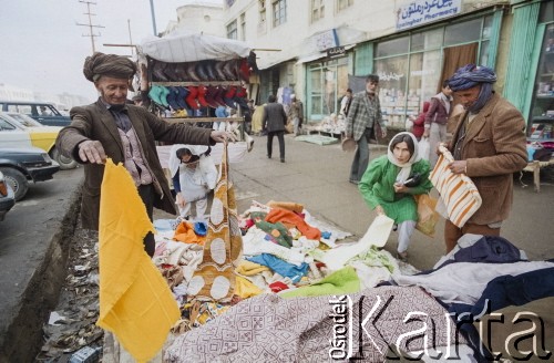 1992, Kabul, prowincja Kabul, Afganistan.
Sprzedawca tkanin na ulicznym stoisku prezentuje swój asortyment.
Fot. Irena Jarosińska, zbiory Ośrodka KARTA