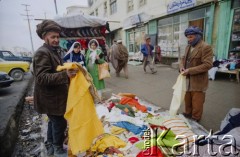 1992, Kabul, prowincja Kabul, Afganistan.
Sprzedawca tkanin na ulicznym stoisku prezentuje swój asortyment.
Fot. Irena Jarosińska, zbiory Ośrodka KARTA