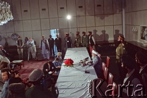 1992, Kabul, prowincja Kabul, Afganistan.
Konferencja prasowa afgańskiego polityka i przywódcy Sibghatullaha Modżaddediego (w białym turbanie). Od 28 kwietnia do 28 czerwca 1992 Modżaddedi pełnił funkcję tymczasowego prezydenta Afganistanu. Objął urząd po wycofaniu się wojsk radzieckich z Afganistanu, wkroczeniu  mudżahedinów do Kabulu i upadku wspieranych przez Sowietów komunistycznych rządów prezydenta Mohammada Nadżibullaha.
Fot. Irena Jarosińska, zbiory Ośrodka KARTA