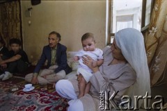 1992, Kabul, prowincja Kabul, Afganistan.
Spotkanie przy herbacie w afgańskim domu. Na zdjęciu kobieta trzyma na rękach niewolę.
Fot. Irena Jarosińska, zbiory Ośrodka KARTA