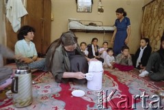 1992, Kabul, prowincja Kabul, Afganistan.
Spotkanie przy herbacie w afgańskim domu. Na zdjęciu młoda kobieta rozlewa napój do filiżanek. Wokół niej na podłodze siedzą zgromadzeni goście.
Fot. Irena Jarosińska, zbiory Ośrodka KARTA
