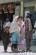1992, Kabul, prowincja Kabul, Afganistan.
Młode kobiety z dzieckiem idą ulicą. Kobiety mają na sobie kolorowe tuniki hidżaby, tradycyjne chusty okrywające włosy i ramiona.
Fot. Irena Jarosińska, zbiory Ośrodka KARTA