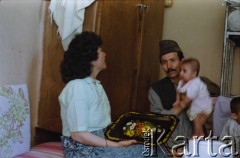 1992, Kabul, prowincja Kabul, Afganistan.
Spotkanie przy herbacie w afgańskim domu. Na zdjęciu kobieta i mężczyzna trzymający na rękach małe dziecko.
Fot. Irena Jarosińska, zbiory Ośrodka KARTA