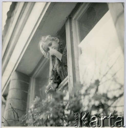 Lata 50. lub 60., Polska.
Dziewczynka wychylająca się przez okno.
Fot. Irena Jarosińska, zbiory Ośrodka KARTA