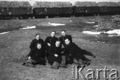 Wiosna 1944, Wierzbałowo (Virbalis), Litwa.
Chłopcy wywiezieni w kwietniu 1943 z okolic Wilna do pracy przymusowej na dużej przygranicznej stacji kolejowej w Kybartach (Kybartai). Stacja nosiła nazwę starszej od miasteczka Kybarty wsi Wierzbałowo odległej o 5 km. Na tle parku wagonowego siedzą od lewej: NN 