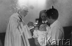 1977, Polska.
Emil Morgiewicz z dzieckiem podczas chrztu, z lewej ksiądz Jan Zieja.
Fot. Janusz Krzyżewski, zbiory Ośrodka KARTA

