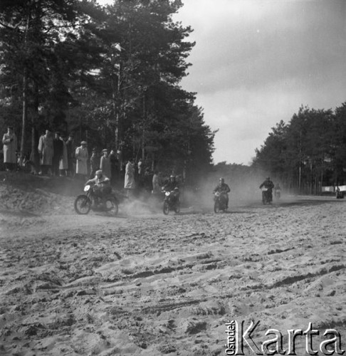 Marzec 1957, Zalesie Górne, Polska.
Zawody motocyklowe, publiczność obserwuje zawodników jadących piaszczystą drogą.
Fot. Romuald Broniarek, zbiory Ośrodka KARTA