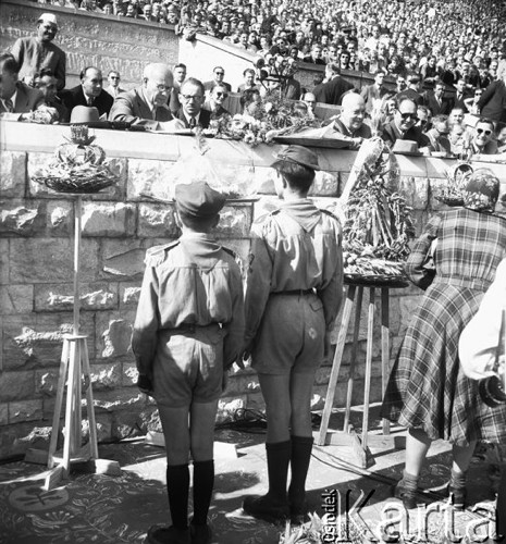 Sierpień 1957, Warszawa, Polska.
Dożynki na Stadionie Dziesięciolecia, dwaj harcerze stoją przed trybuną honorową, na której siedzą m.in. Władysław Gomułka i Józef Cyrankiewicz.
Fot. Romuald Broniarek, zbiory Ośrodka KARTA