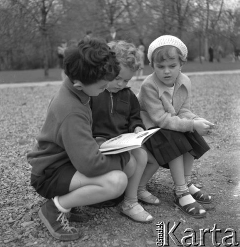 Maj 1958, Warszawa, Polska.
Kiermasz książki - trójka dzieci ogląda książkę z obrazkami.
Fot. Romuald Broniarek, zbiory Ośrodka KARTA