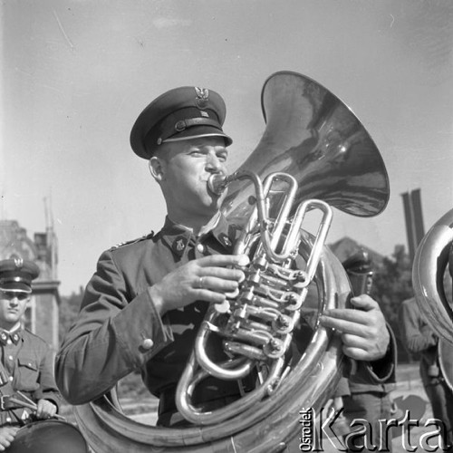 Maj 1958, Polska.
Powitanie radzieckich zawodników, uczestników Motorowego Rajdu Przyjaźni - Moskwa-Warszawa-Moskwa. Muzyk wojskowej orkiestry gra na instrumencie dętym.
Fot. Romuald Broniarek, zbiory Ośrodka KARTA