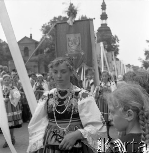 Czerwiec 1958, Łowicz, Polska.
Uroczystości Bożego Ciała - procesja z chorągwiami i feretronami, na pierwszym planie kobieta w stroju ludowym.
Fot. Romuald Broniarek, zbiory Ośrodka KARTA