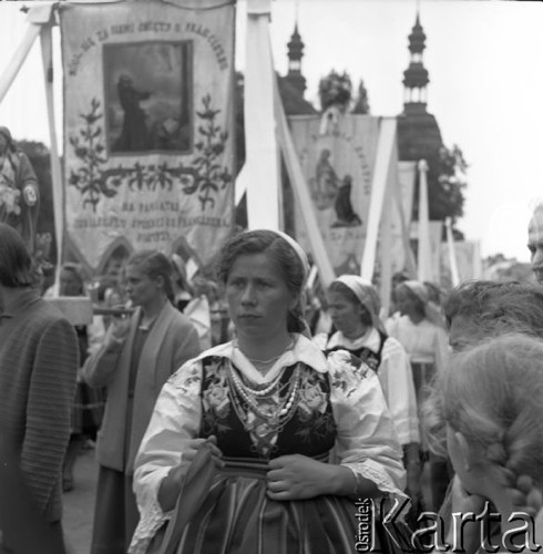 Czerwiec 1958, Łowicz, Polska.
Uroczystości Bożego Ciała - procesja z chorągwiami i feretronami, na pierwszym planie kobieta w stroju ludowym.
Fot. Romuald Broniarek, zbiory Ośrodka KARTA