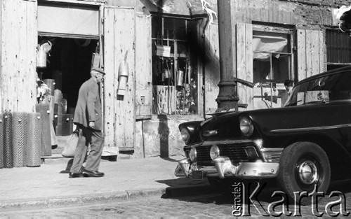 Wrzesień 1958, Warszawa, Polska.
Mężczyzna przechodzi przed sklepem z artykułami żelaznymi, przed drzwiami sklepu stoją bele siatki ogrodzeniowej.
Fot. Romuald Broniarek, zbiory Ośrodka KARTA