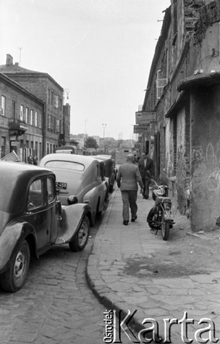 Wrzesień 1958, Warszawa, Polska.
Przechodnie na ulicy, z lewej parkujące samochody, z prawej motocykl.
Fot. Romuald Broniarek, zbiory Ośrodka KARTA