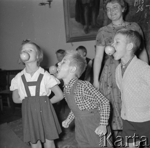 Wrzesień 1958, Warszawa, Polska.
Zabawa dla dzieci w siedzibie Zarządu Głównego TPPR, dzieci jedzą jabłka wiszące na nitkach.
Fot. Romuald Broniarek, zbiory Ośrodka KARTA