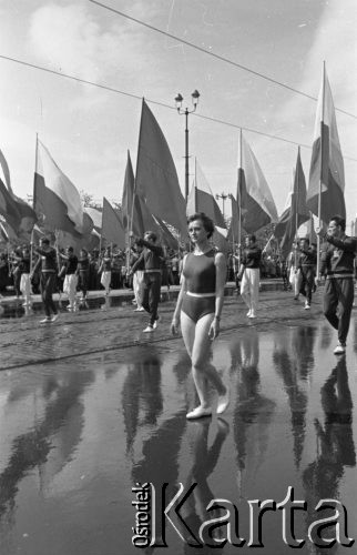 1.05.1959, Warszawa, Polska. 
Obchody święta 1 Maja, pochód przechodzący ulicą Marszałkowską, na pierwszym planie kobieta w stroju sportowym, za nią idą sportowcy z flagami PRL i ZSRR. 
Fot. Romuald Broniarek, zbiory Ośrodka KARTA