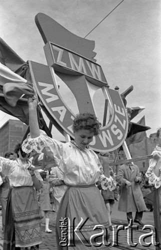 1.05.1959, Warszawa, Polska. 
Obchody święta 1 Maja, pochód przechodzący ulicą Marszałkowską, kobieta w stroju regionalnym z transparentem Związku Młodzieży Wiejskiej Mazowsze. 
Fot. Romuald Broniarek, zbiory Ośrodka KARTA