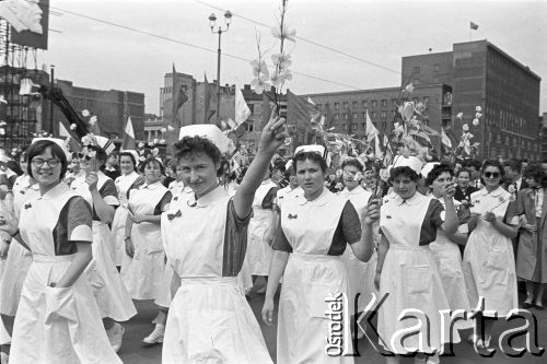 1.05.1959, Warszawa, Polska. 
Obchody święta 1 Maja, ulica Marszałkowska, pielęgniarki z kwiatami idące w pochodzie, w lewym górnym rogu fragment portretu Włodzimierza Lenina. 
Fot. Romuald Broniarek, zbiory Ośrodka KARTA