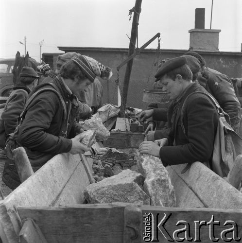 Luty 1975, Nowy Targ, Polska.
Czwartkowy targ w Nowym Targu, mężczyźni kupujący sól dla zwierząt.
Fot. Romuald Broniarek, zbiory Ośrodka KARTA 

