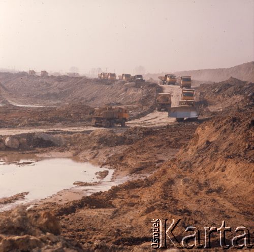 Marzec 1975, Dąbrowa Górnicza, woj. Katowice, Polska.
Budowa Huty Katowice, ciężarówki wywożące ziemię z placu budowy.
Fot. Romuald Broniarek/KARTA