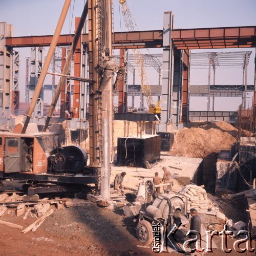 Marzec 1975, Dąbrowa Górnicza, woj. Katowice, Polska.
Budowa Huty Katowice, robotnicy podczas pracy, na pierwszym planie stoi betoniarka.
Fot. Romuald Broniarek/KARTA
