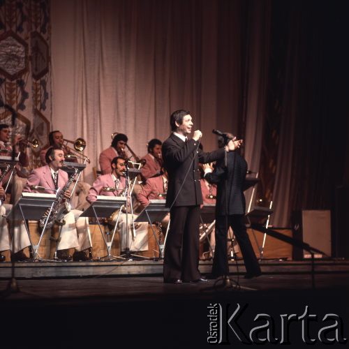 Kwiecień 1975, Warszawa, Polska.
Dni Kultury Radzieckiej, koncert galowy w Sali Kongresowej Pałacu Kultury i Nauki, na pierwszym planie piosenkarz z mikrofonem, w tle orkiestra.
Fot. Romuald Broniarek/KARTA
