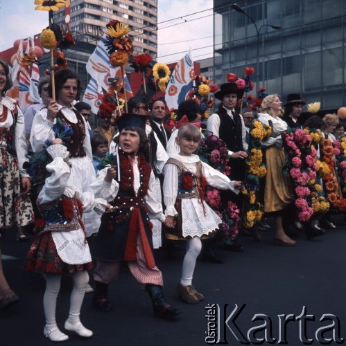 1.05.1975, Warszawa, Polska. 
Obchody święta 1 Maja, uczestnicy pochodu przechodzą ulicą Marszałkowską, na piewszymn planie dzieci w strojach regionalnych.
Fot. Romuald Broniarek/KARTA
