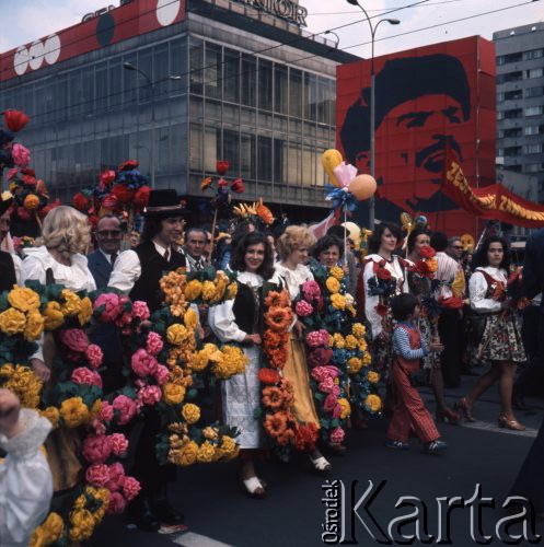 1.05.1975, Warszawa, Polska. 
Obchody święta 1 Maja, uczestnicy pochodu w strojach regionalnych przechodzą ulicą Marszałkowską, w tle portret Włodzimierza Lenina.
Fot. Romuald Broniarek/KARTA
