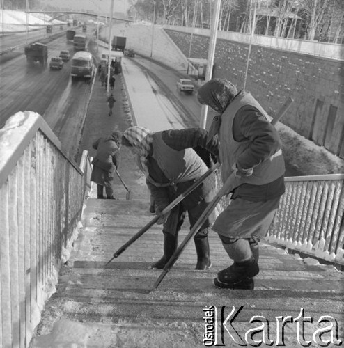 Grudzień 1975, Warszawa, Polska.
Plac na Rozdrożu, pracownice Miejskiego Przedsiębiorstwa Oczyszczania sprzątają oblodzone schody, prowadzące na przystanek autobusowy przy Trasie Łazienkowskiej.
Fot. Romuald Broniarek/KARTA
