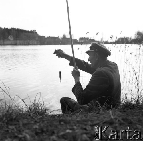 Maj 1956, Mazury, Polska.
Mężczyzna ze złowioną na wędkę rybą.
Fot. Romuald Broniarek, zbiory Ośrodka KARTA