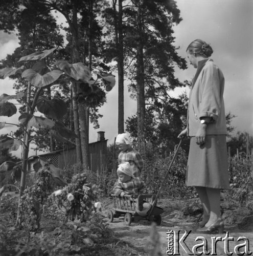 Lipiec 1956, Lubelszczyzna, Polska.
Kobieta z dwójką dzieci w ogrodzie.
Fot. Romuald Broniarek, zbiory Ośrodka KARTA